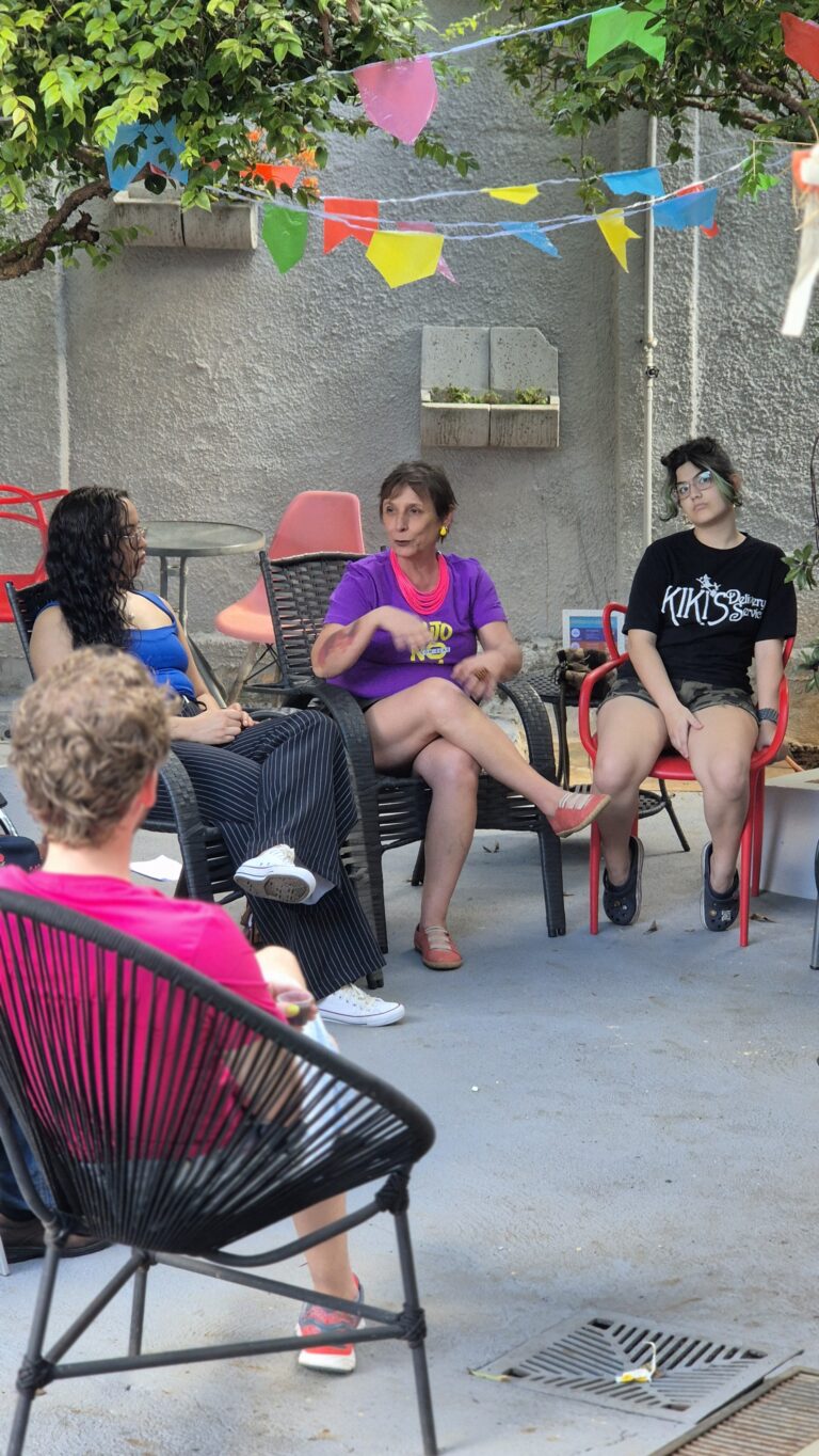 Mulheres sentadas em roda, conversando em um encontro ao ar livre